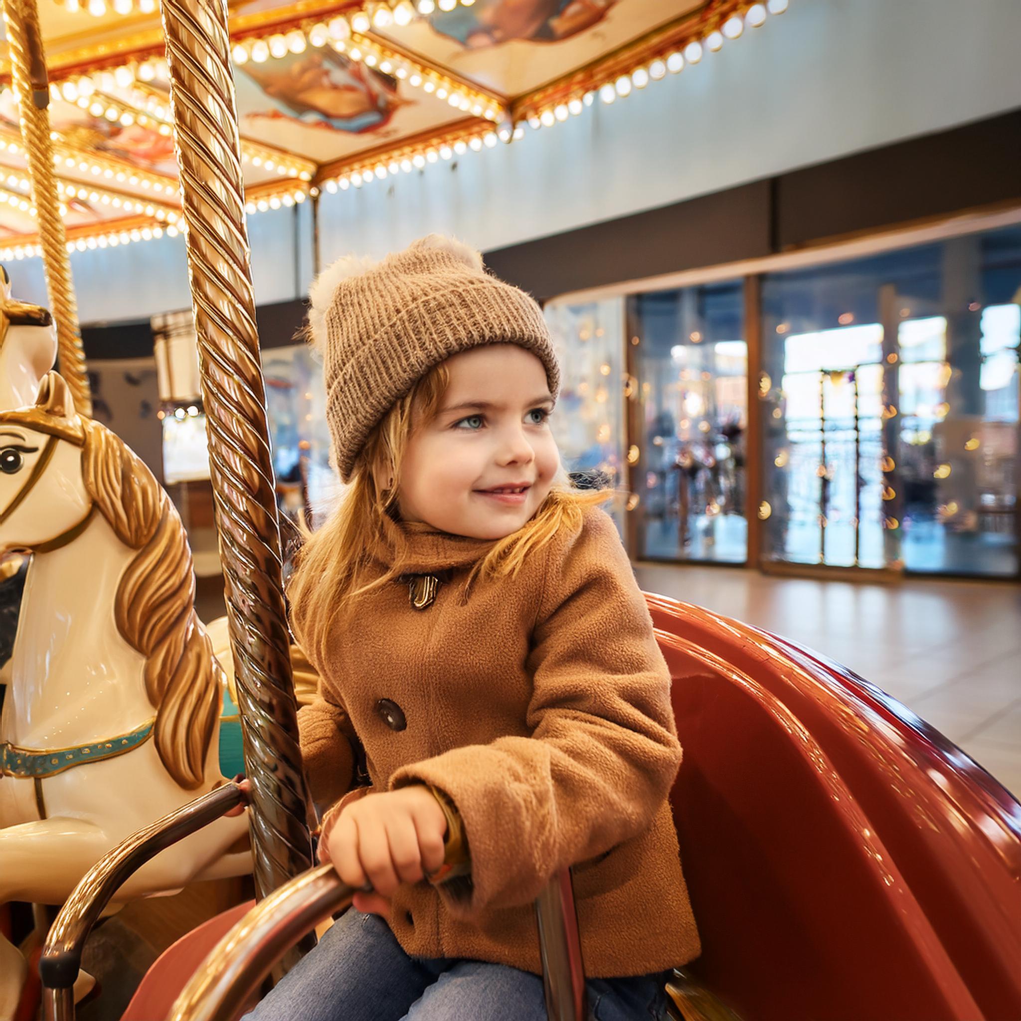 Riding the carousel at the mall while shopping for boots